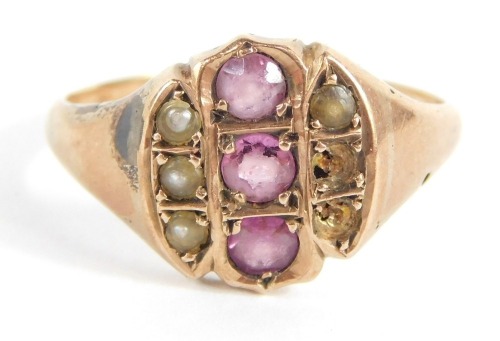 A Victorian dress ring, the central circular panel with three amethysts, and outer rows of three seed pearls (2 missing), on a rose gold coloured band, unmarked, ring size O, 3.2g all in.