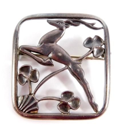 A Geoffrey G Bellamy silver deer brooch, depicting a deer jumping, over flowers, in square frame, 4cm x 4cm, signed and numbered 115, 16g all in.