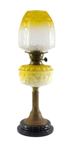 A Victorian white and yellow opaline glass and brass oil lamp, with a fluted column and floral moulded glass reservoir, no chimney, and an etched and moulded octagonal glass shade, 60cm high.