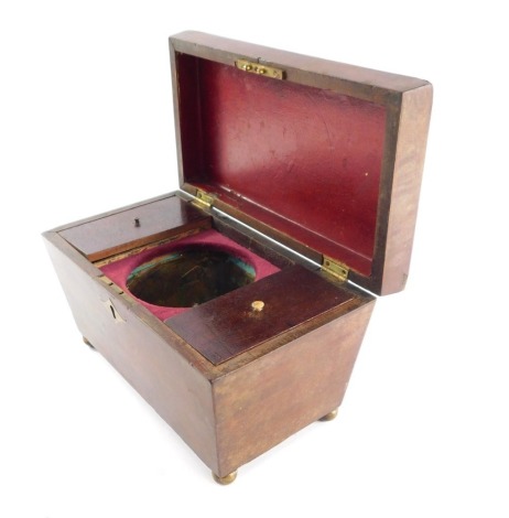 A Regency mahogany tea caddy, of sarcophagus form, opening to reveal two compartments flanking a mixing bow recess, raised on brass ball feet, 16cm x 26cm x 14.5cm.