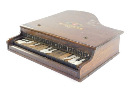 A Japanese wooden cased toy Grand Baby Piano, bears decal to top, 32cm wide. (AF)