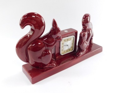 A French mid pottery mantel clock, scout square dial bearing Arabic numerals, clockwork movement, the square clock case flanked by a pair of squirrels, raised on a rectangular base, 38cm wide. - 3