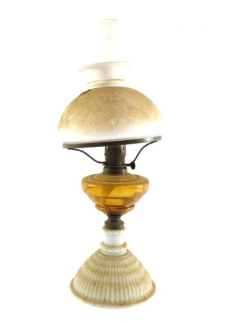 A Victorian opalescent glass oil lamp, with amber glass reservoir, glass chimney, and white glass shade, 52cm high.