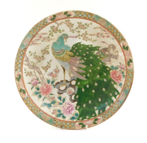 A Japanese kakiemon porcelain charger, decorated with peacocks and peonies, brown painted mark, 37cm diameter.