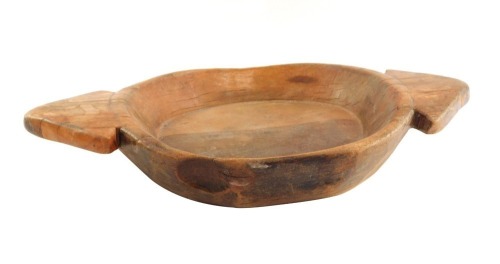 A turned wooden twin handled bowl, possibly northern European, with two triangle shaped handles, 65cm wide, 40cm deep.