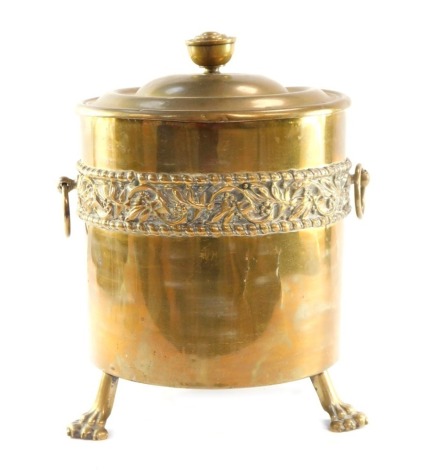 A brass coal box and cover, embossed with a band of mistletoe, on three lion's paw feet, 40cm high.