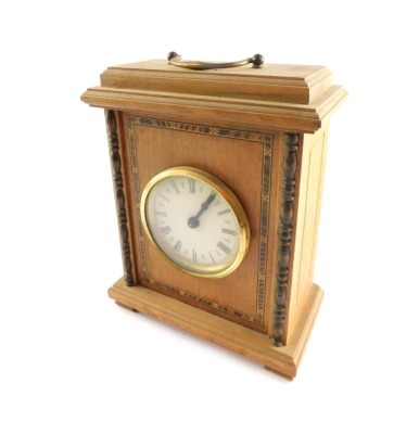 A late 20thC walnut cased mantel clock, circular dial bearing Roman numerals, clockwork movement with bell strike, the rectangular set top with swing handle, on turned column supports, and outer marquetry banding, on square set feet, 25cm high, 19cm wide,