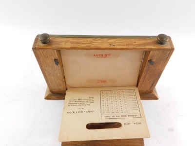 An early 20thC perpetual desk calendar, the rectangular top with paper inset, month dials and brass outer casing with turn dials stamped Manco Electroplate, on a wooden base, 13cm high, 21cm wide, 4cm deep. - 3