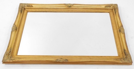 A Victorian style gilt framed rectangular wall mirror, with floral scroll capped detailing and arch top, on a bevelled mirror plate, 78cm x 112cm.