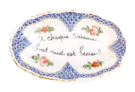 A Sevres type porcelain pin dish, painted with flowers and bearing 'A Chaque Oiseau...Sout nuit est Peau!!', against a scale blue ground, bears painted mark, 10cm diameter.