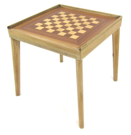 A 1952 Prestopak games table, the square top with two ply wooden chess board section and back leather inset, with four legs, the casing 52cm x 52cm, the legs 50cm high.