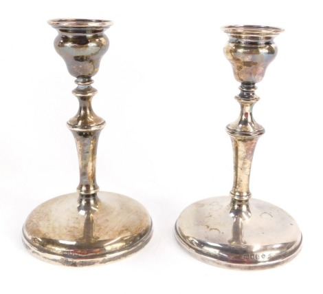 A pair of George V loaded silver candlesticks, each of turned form, London 1915, 15cm high.