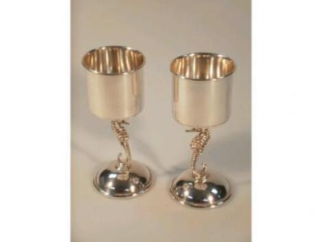 A pair of unusual cylindrical goblets with seahorse stems on circular bases