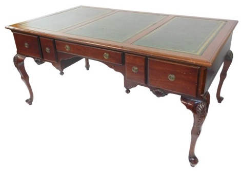 A Chippendale style mahogany partner's desk, with a triple section gilt tooled green leather top, above one long and four deep drawers to each side, raised on shell carved cabriole legs, 77cm high, 164cm wide, 95cm deep.