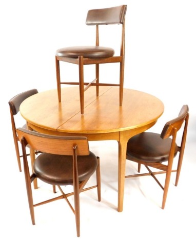 A Nathan teak circular draw leaf dining table, with one additional leaf, raised on tapering square legs, 75cm high, 122cm diameter, together with four G-Plan 1960's teak dining chairs, by Leslie Dandy, upholstered in brown leatherette. (5)