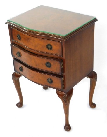 A Georgian style burr walnut serpentine bedside chest, of three graduated drawers, raised on shell carved cabriole legs, 59cm high, 45cm wide, 37cm deep.