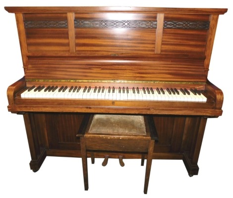 A Victorian walnut cased upright piano, overstrung with three panelled top with carved friezes, and later stool, 128cm high, 143cm wide, 60cm deep.