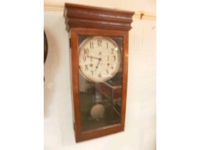 An early 20thC wall clock in oak case with cylindrical dial