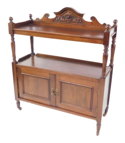 A Victorian mahogany buffet, the carved shield backed shelf top above a shelf topped pair of panelled doors, united by turned supports, on castors, 120cm high, 104cm wide, 40cm deep.