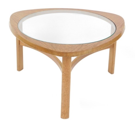 A mid century Nathan teak coffee table, the shaped triangular top with central circular glass insert, raised on square legs, united by curved stretchers, 44cm high, 77cm wide.