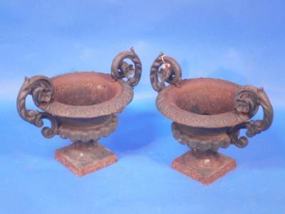 A pair of cast iron squat campana vases with scrolled handles