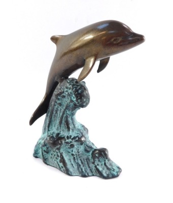 A bronze figure of a dolphin riding the crest of a wave, with blue patinated finish, 16cm high.