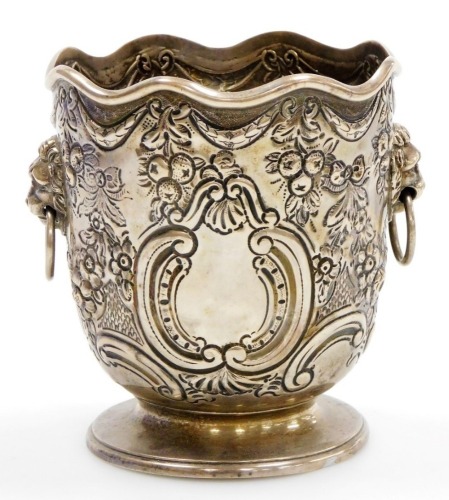 A Victorian silver bottle holder of Monteith form, with a waved rim, the body embossed with bows, swags, fruit, flowers and scrolls, with twin lion's head and ring handles, on a footed base, Daniel and John Welby, London 1898, 5½oz, 11cm high.