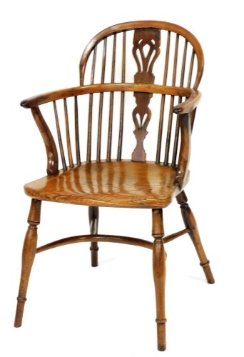 A 19thC yew and elm Windsor chair, with a pierced splat, spindle turned supports and a solid seat, on turned legs with crinoline stretcher.