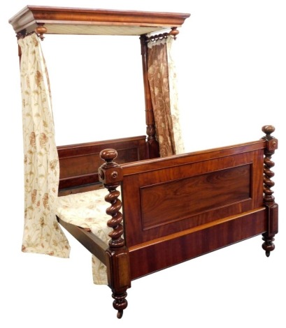 A Victorian mahogany half tester bed, the mahogany canopy with drop turned finals supported with lappet carved turned back posts, flanking a panelled headboard, the footboard with similar panelling and spiral turned supports with bun feet and castors, 225