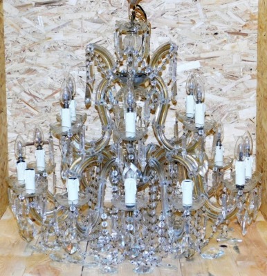 A cut glass chandelier, with rows of beads and faceted lustre drops, formed as two tiers of six and twelve arms, 79cm wide.