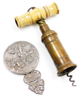 A 19thC Thomason type ivory and copper barrel corkscrew, lacking brush, 14cm long, and a Danish white metal hand mirror, in the manner of Hans Jensen, repousse decorated with a pastoral scene, stamped Denmark, 11cm long. (2)