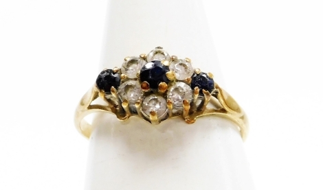 A 9ct gold cluster ring, the central cluster set with blue and white paste stones formed as a flower in a raised basket setting, ring size J½, misshapen, 1.5g all in.