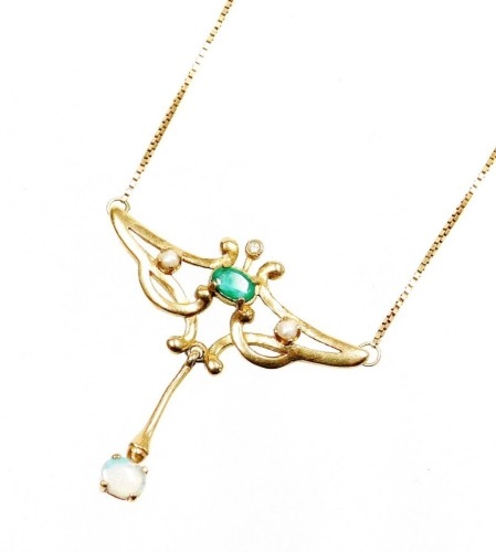 An Art Nouveau style pendant, the arched top set with central oval cut emerald in four claw setting with seed pearl and tiny diamond set mounts, with an opal set drop on applied box link neck chain, stamped 375, the pendant 3cm wide and 4cm drop, the chai