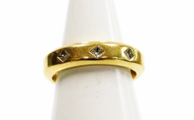 An 18ct gold wedding band, set with three tiny diamonds in a star setting, with applied adjuster clips to inner band, ring size K½, 8g all in.