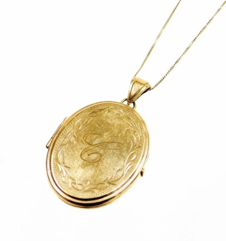 A 9ct gold locket and chain, the circular locket of plain outer design but bearing the initial C with outer scroll detailing, 4cm high, on a fine link 9ct gold chain, 40cm long, 13.4g all in.