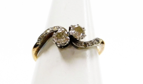 An 18ct gold and platinum diamond twist ring, set with two old cut diamonds in claw setting, with tiny diamond set platinum shoulders, ring size M½, 2.3g all in.