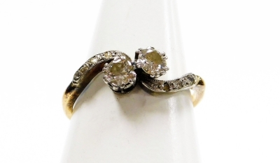 An 18ct gold and platinum diamond twist ring, set with two old cut diamonds in claw setting, with tiny diamond set platinum shoulders, ring size M½, 2.3g all in.