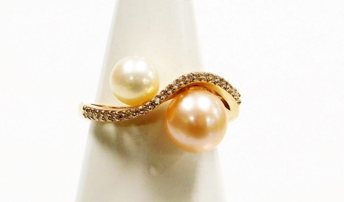 Withdrawn presale by vendor- An Atlo 18ct rose gold pearl dress ring, the twist design band set with tiny diamonds with two cultured pearls, one in cream lustre finish, the other in pink lustre finish, on a raised and pierced design band, ring size P, 4.4