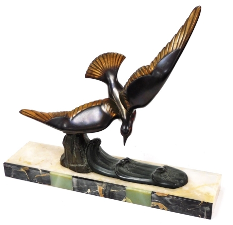 A Continental Art Deco cast metal and marble sculpture of a diving bird, modelled mounted on the crest of a wave, raised on a rectangular marble base, 50cm wide.