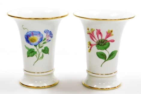 A pair of Meissen outside decorated porcelain vases, of trumpet form, one painted with convolvulus, the other with honeysuckle, struck through blue cross swords mark, 14cm high.