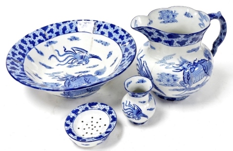 A Masons ironstone blue and white wash set, transfer decorated with a dragon and phoenix in the clouds, chasing flaming pearls, within in a cracked ice border, comprising wash jug and bowl, toothbrush holder and soap dish and cover. (4)