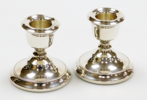 A pair of Elizabeth II silver squat candle sticks, by A T Cannon Ltd, Birmingham 1973, loaded bases, 6.5cm high.