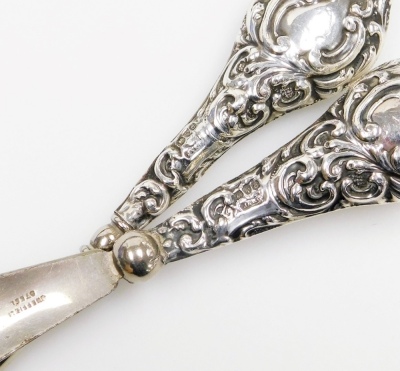 A group of small silver, to include a late Victorian silver match cover, repousse decorated with vacant cartouche, birds, scrolls, etc., Chester 1899, a three leaf clover brooch, 5cm high, boxed, a pair of knife rests, condiment lids, button hook, etc., w - 5