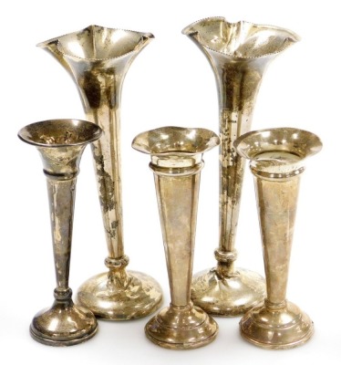 A group of silver bud vases, a pair of bud vases with beaded rims and tapering stems on a circular bases, Birmingham 1908, 17cm high, a further pair with loaded bases, Birmingham 1942, 11.5cm high, and a single example with loaded base, 12cm high. (5, AF)