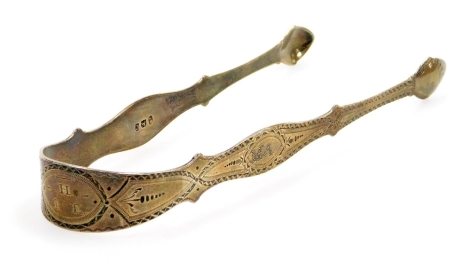 A pair of Georgian silver sugar tongs, with bright cut decoration and initialled, 1oz, 15cm long.