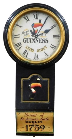 A Guinness advertising wall clock, the circular dial with Arabic numerals and Always Time For A Guinness Extra Stout face, the body with a raised toucan with a pint of Guinness on its beak motif, painted Brewed at St James Gate Dublin since 1759 to base, 