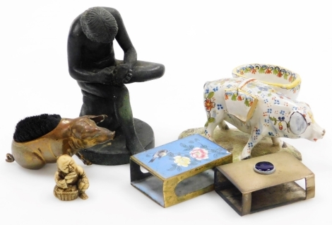 A group of small cabinet items, a brass pen wipe in the form of a pig, 8.5cm wide, a 19thC faience pig with basket on a circular base, 11.5cm wide, an ivory Japanese netsuke in the form of an old man kneeling over a basket of food, 3cm high, two match cas