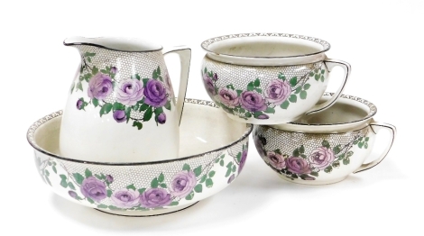 An early 20thC Wedgwood and Co pottery wash set, printed in purple with roses, printed marks, comprising wash jug and bowl, and a pair of chamber pots. (4)