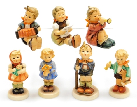 A group of seven small Goebel Hummel figures, comprising girl with trumpet, girl with sheet music, Little Hiker, girl with doll, boy with wooden horse and girl with nosegay, and Accordian Boy.