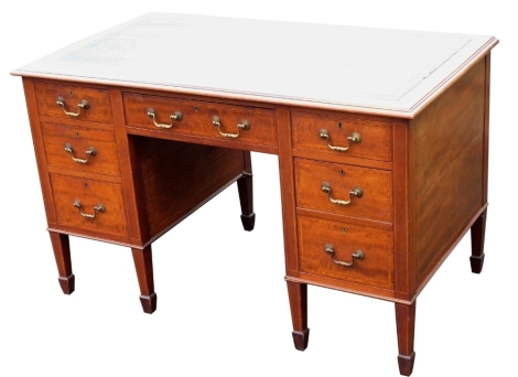 An Edwardian mahogany satinwood cross banded knee hole desk, the rectangular top with a black leather inset and a moulded border above an arrangement of seven drawers, each with drop brass handles, on square tapering legs and spade feet, 75cm high, 120cm 